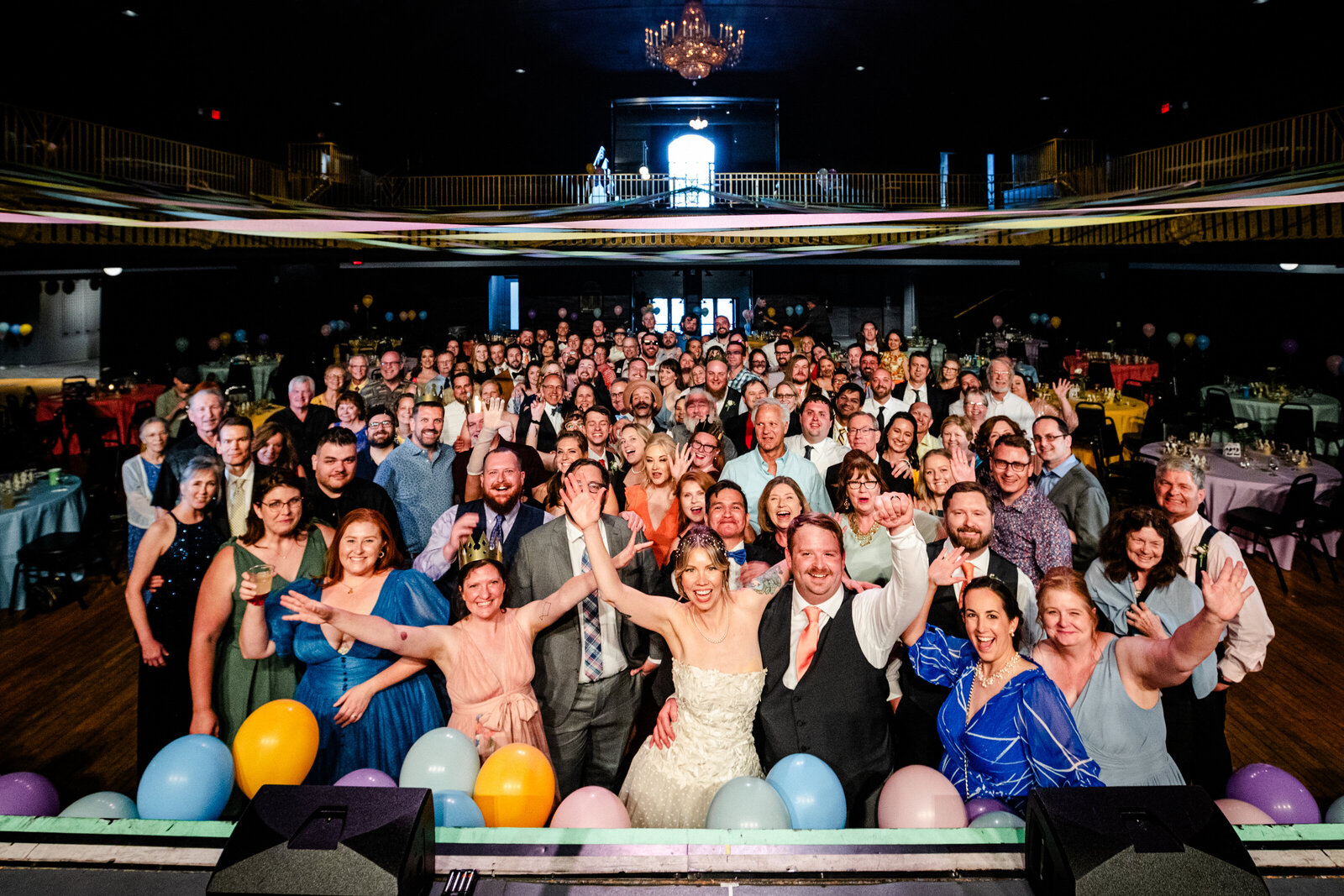 Photo of entire wedding reception waving at the camera