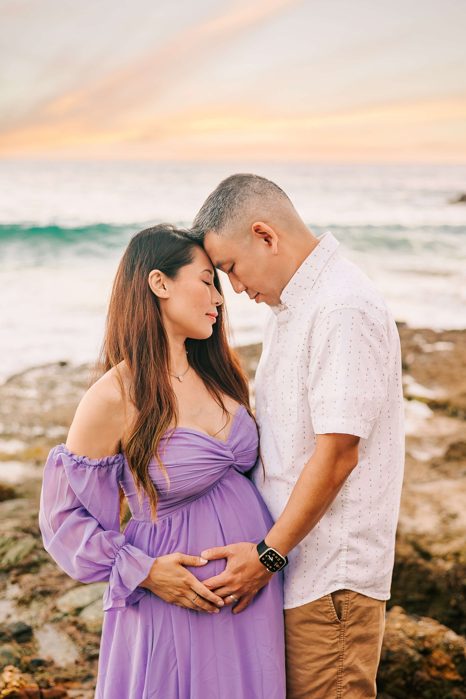 Couple embraced during maternity session at Laguna Beach by Ashley Nicole.