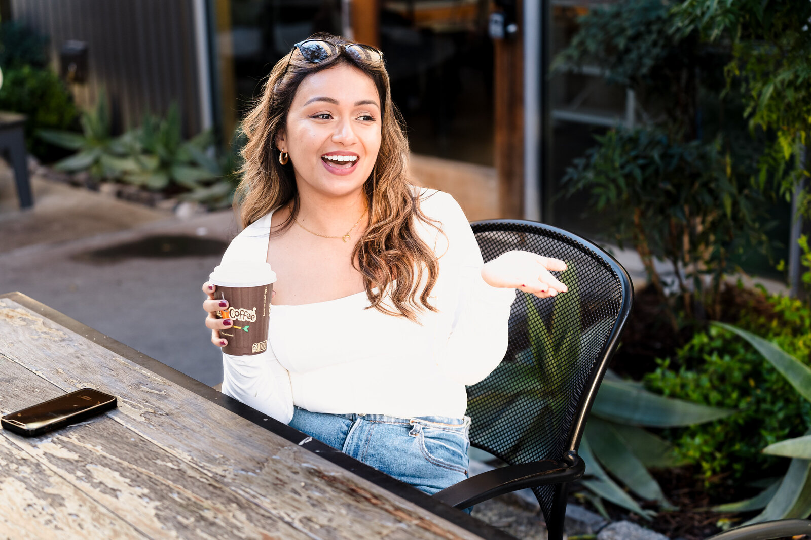 life coach laughs and talks to someone in a coffee shop