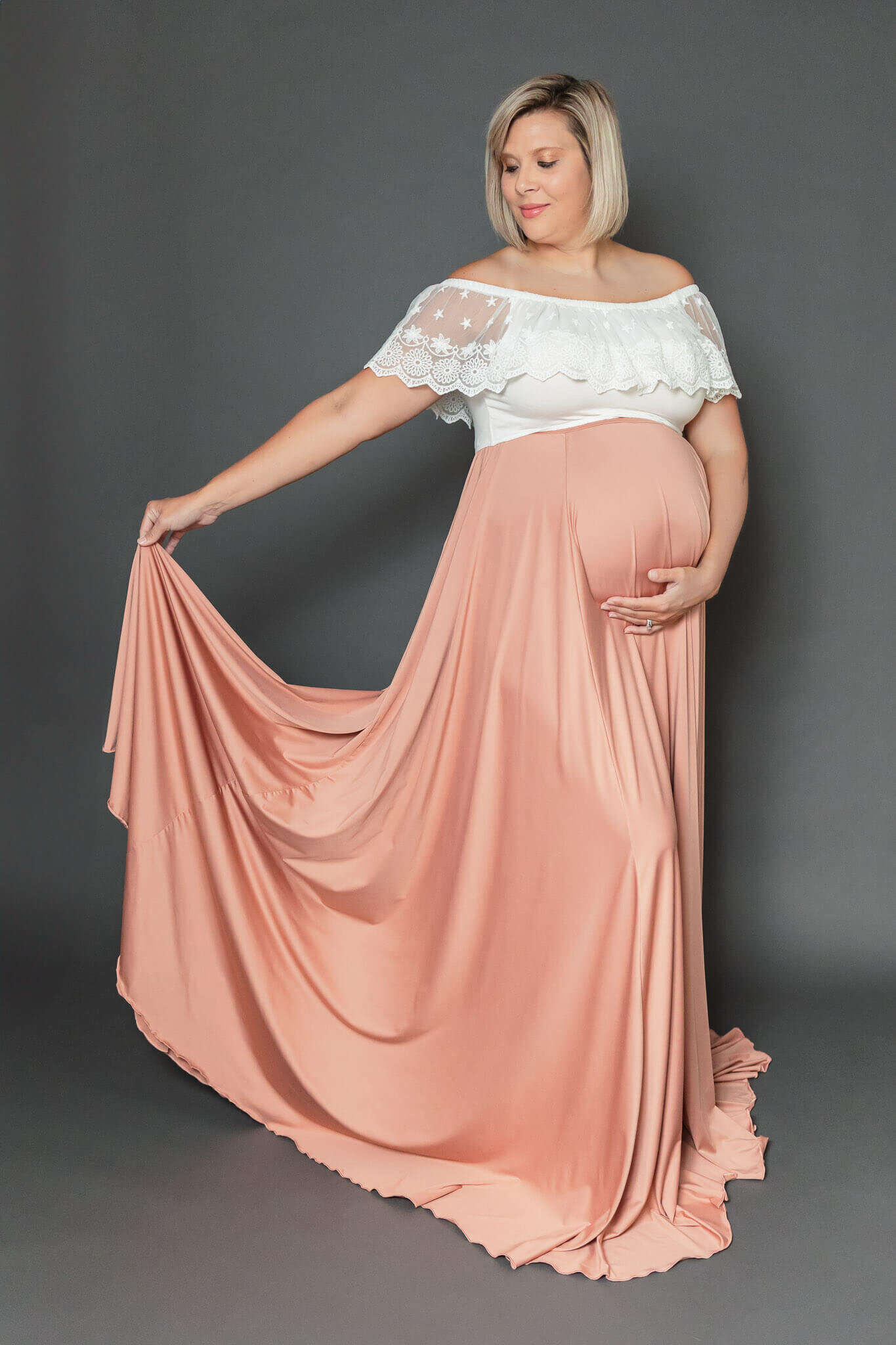 A mother-to-be wearing a pink skirt and white top during her Northern Virginia maternity photography session.