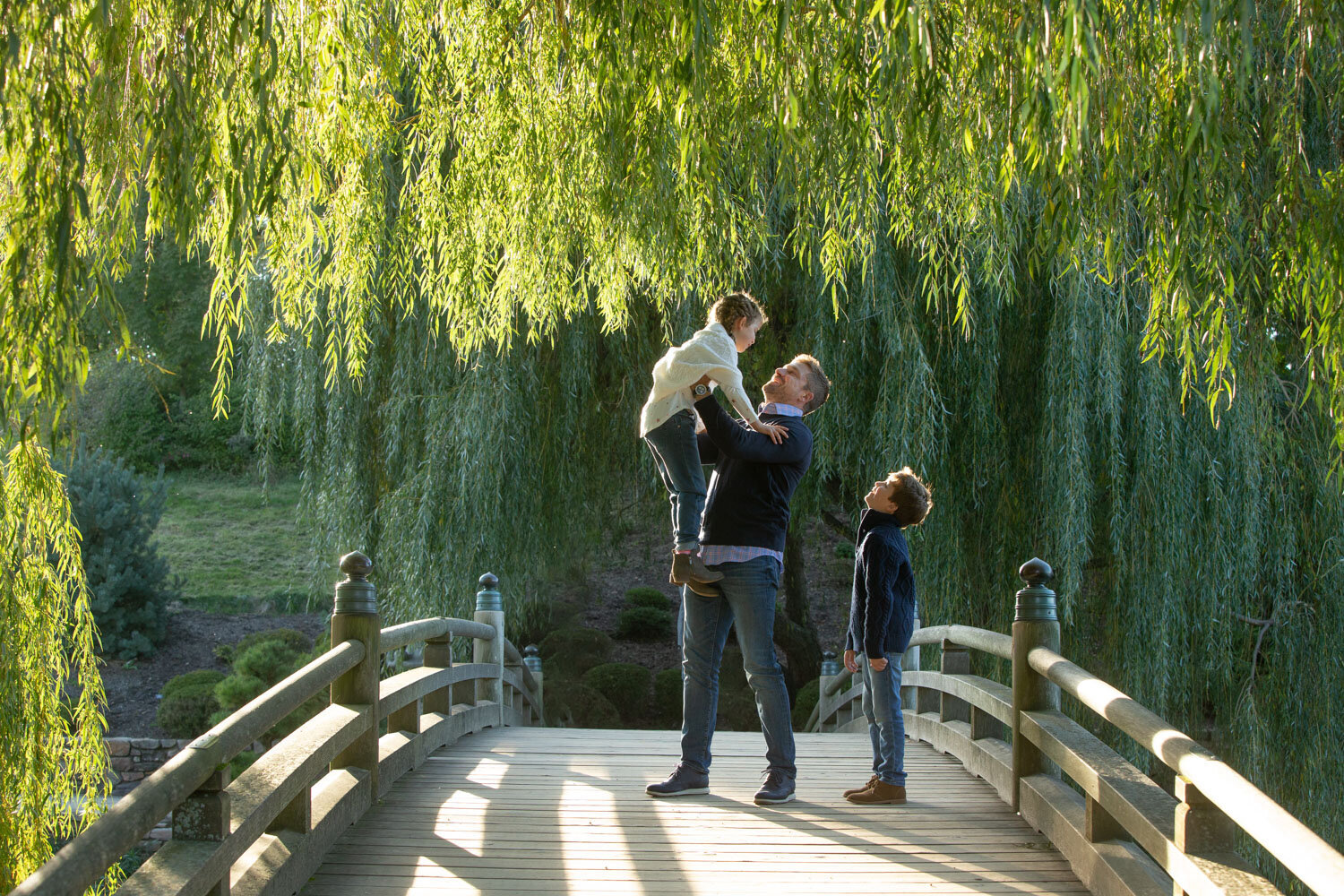 A man carrying a child on his shoulders on a bridge