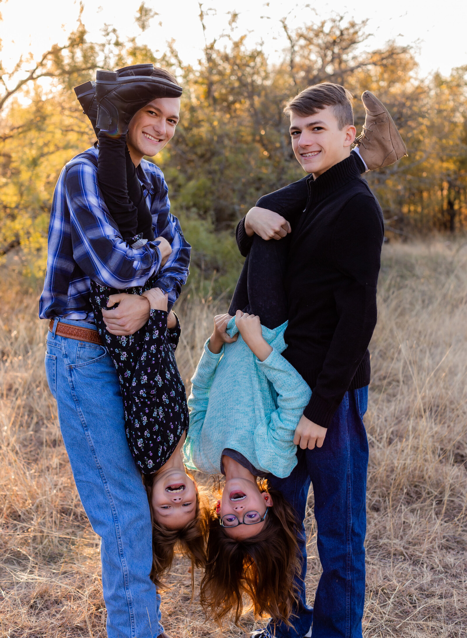 brothers holding little sisters upside down