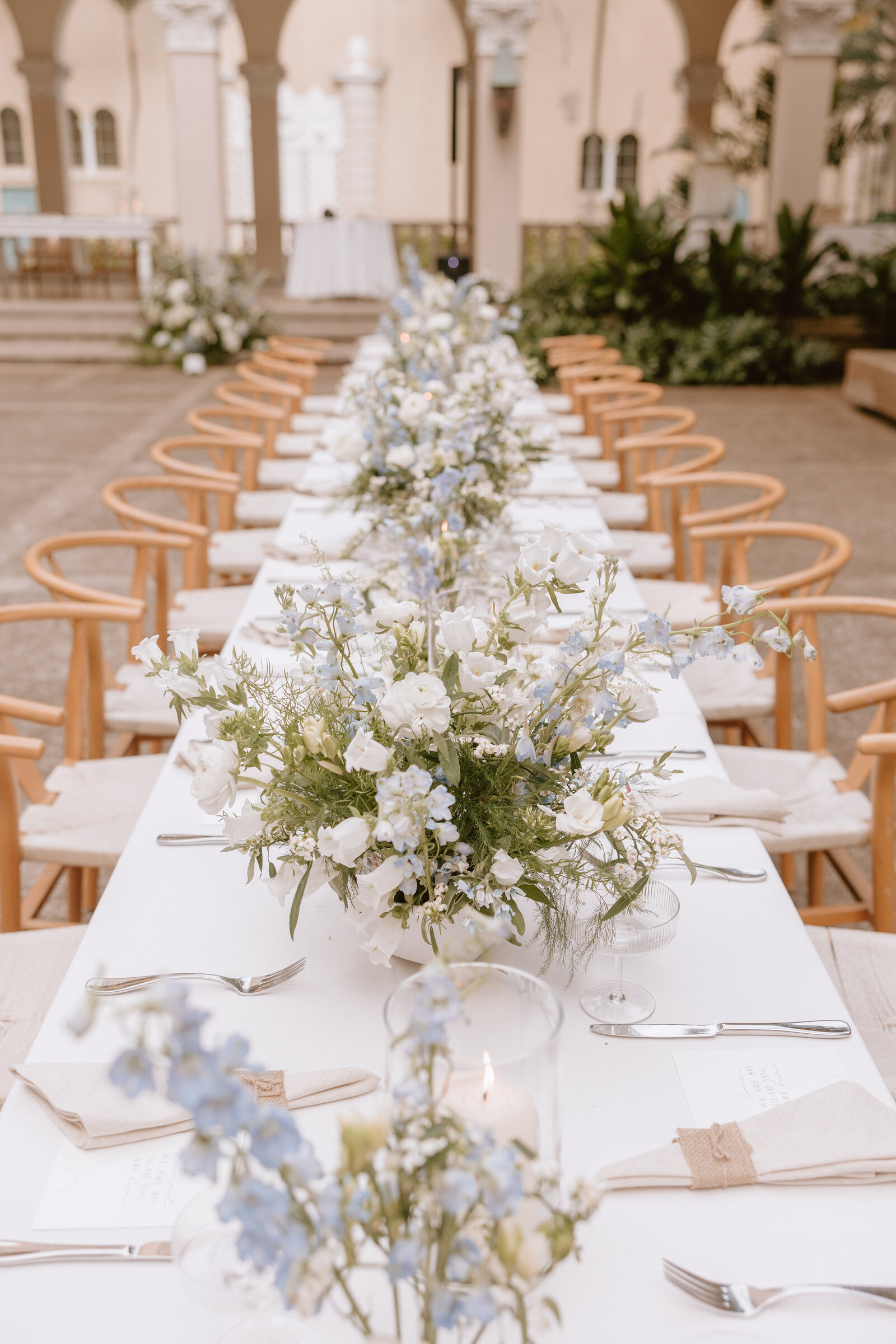 Wedding ceremony long table with florals and wishbone chairs at cafe julia hawaii
