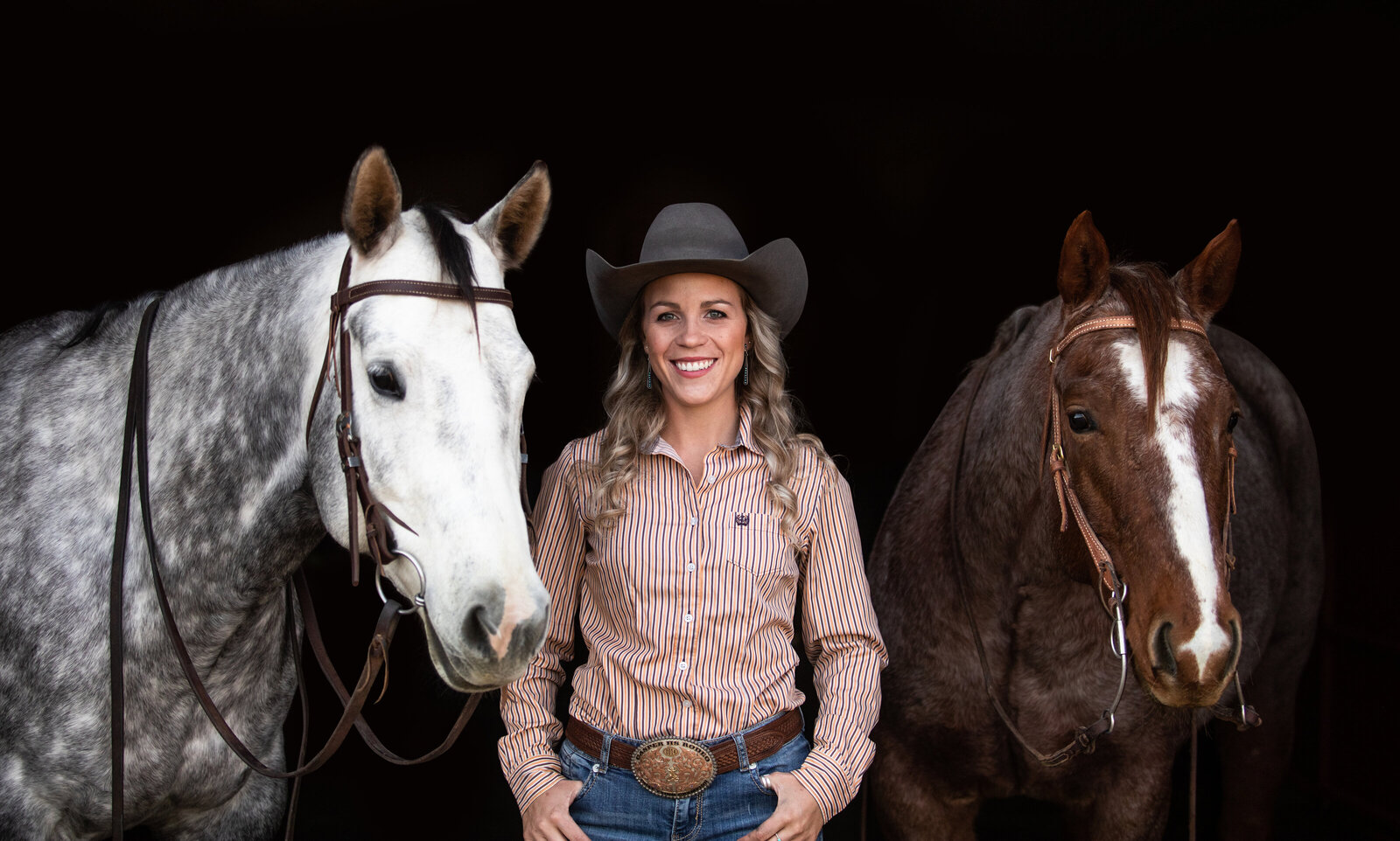 Cowgirl poses with performance horses