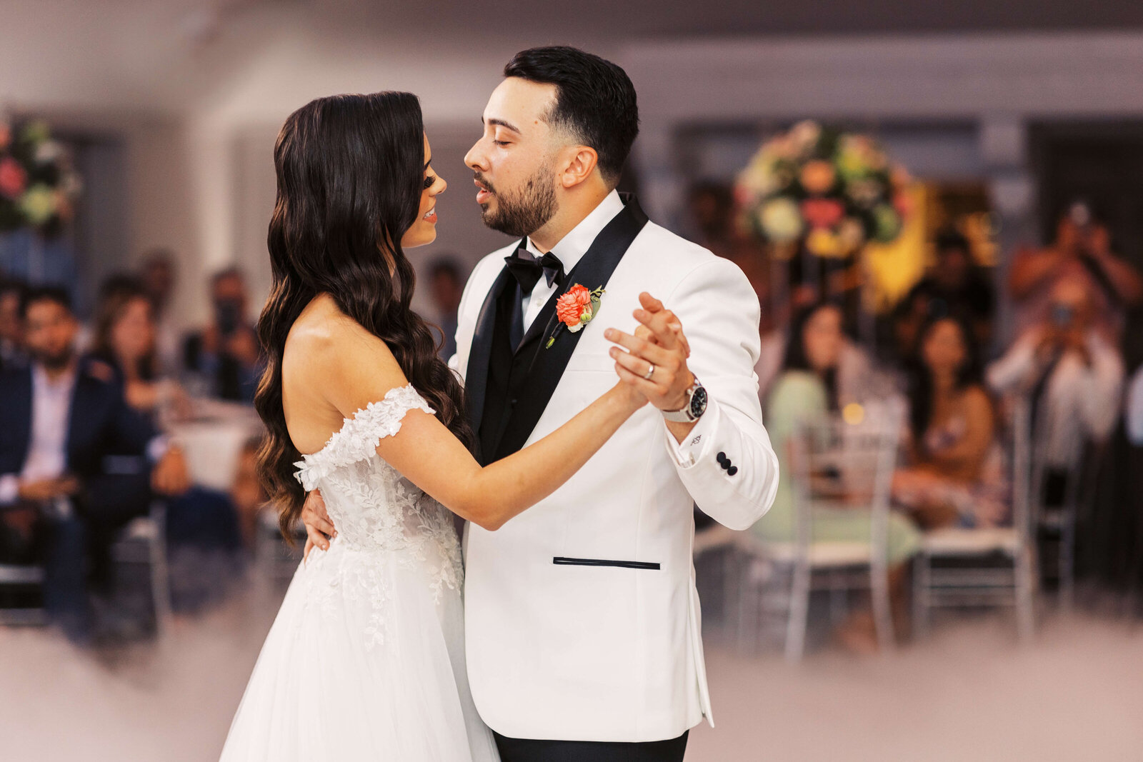 Husband and wife share their first dance in front of their family and friends.