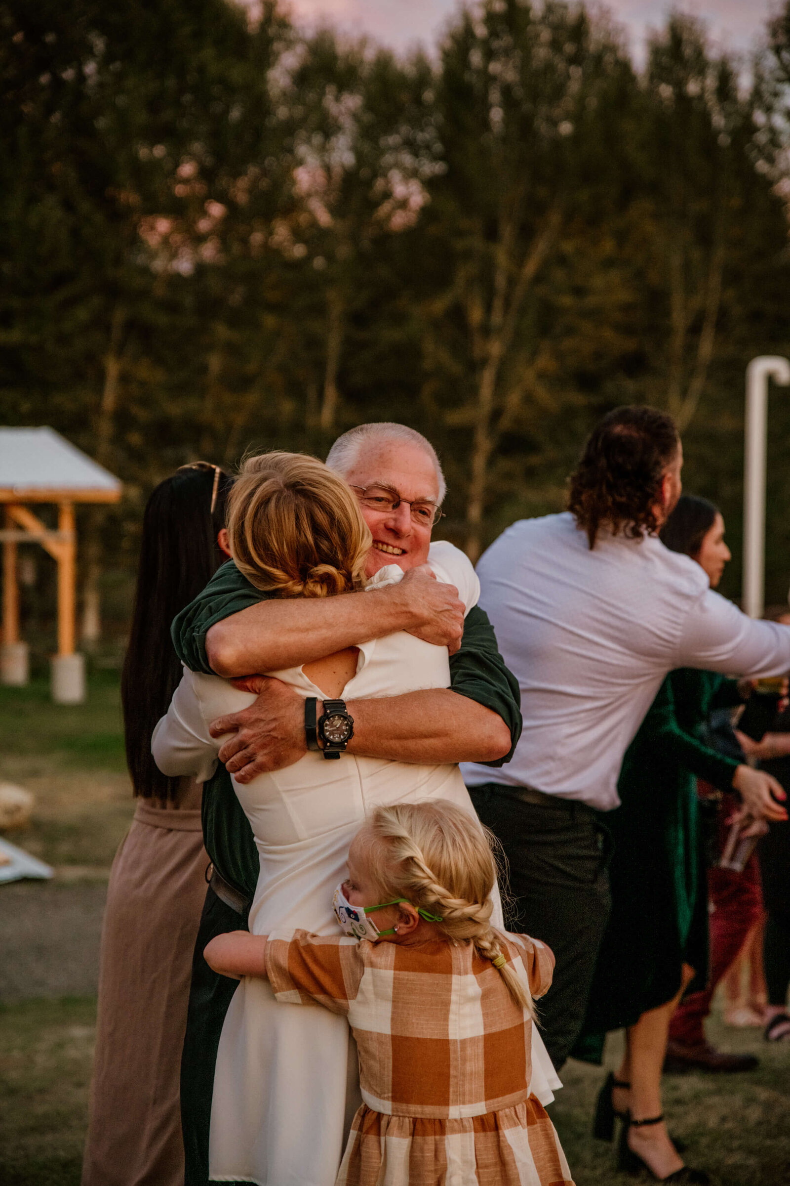 Family embracing Bride after ceremony.