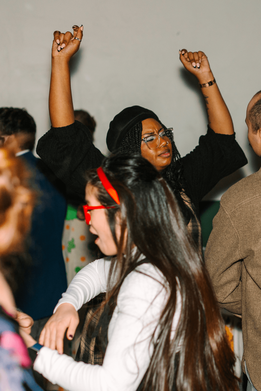A crowd dancing on the wedding dance floor, arms raised above their heads
