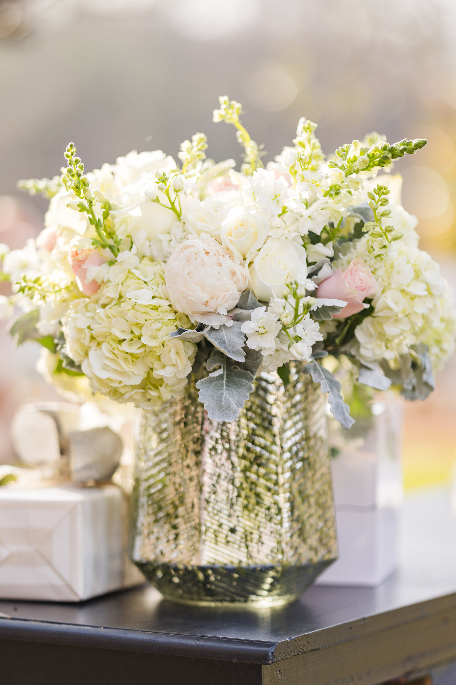 A stunning arrangement of fresh flowers displayed in a beautiful silver vase, adding a touch of sophistication and romance to the wedding décor.
