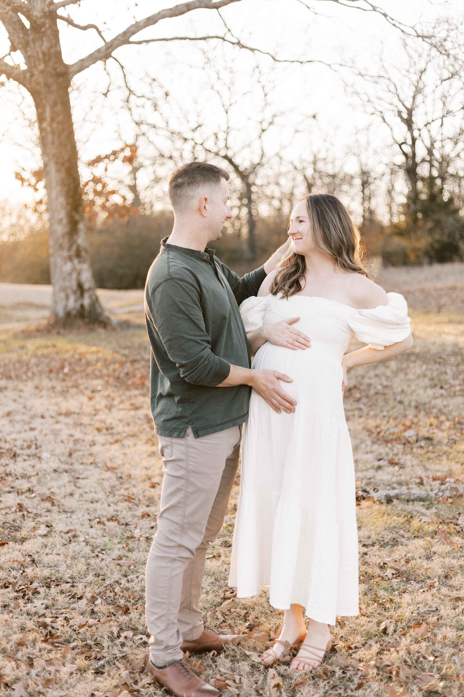woman looking at husband smiling during peoria illinois maternity photos 