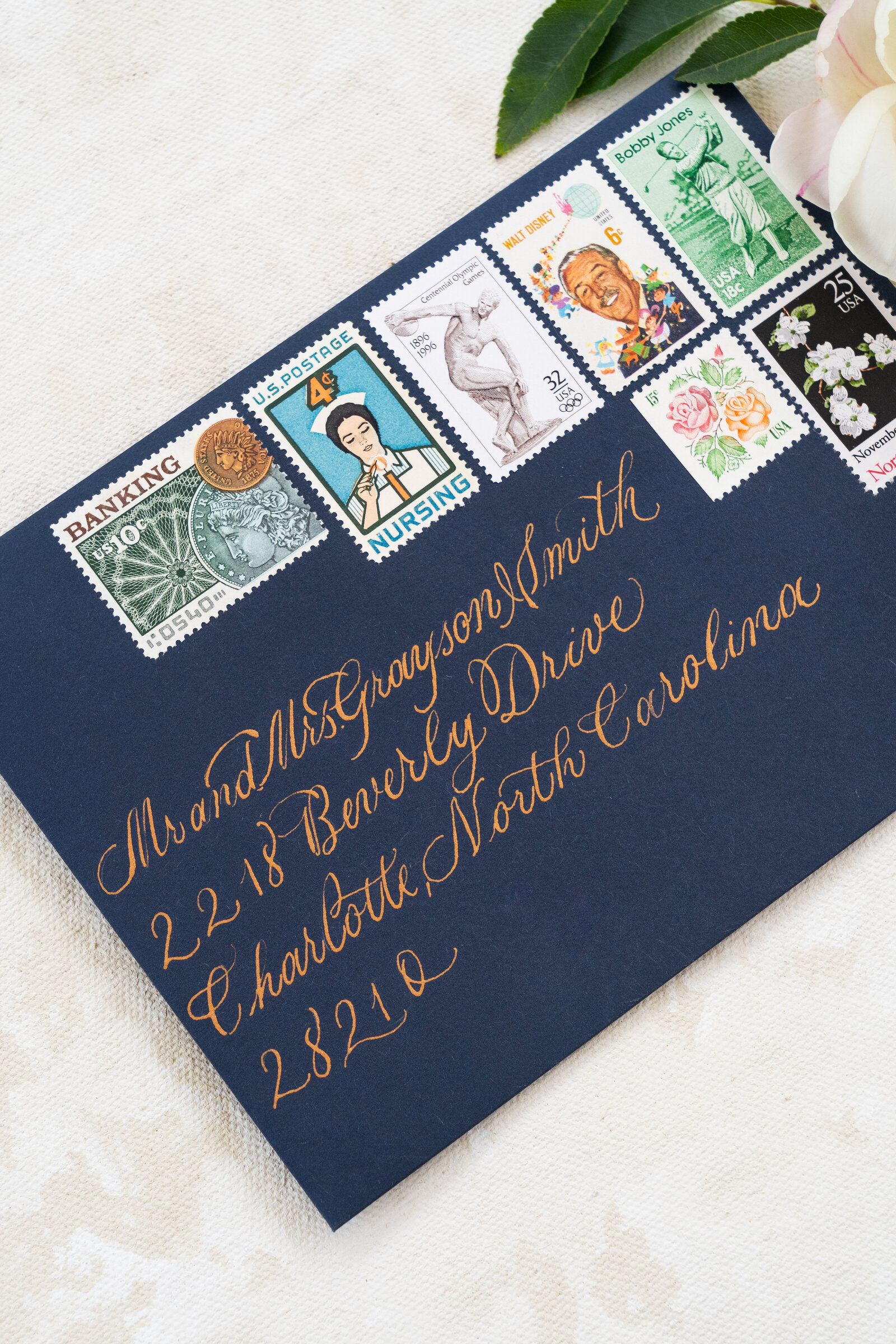 Photo shows gold calligraphy on a navy blue envelope