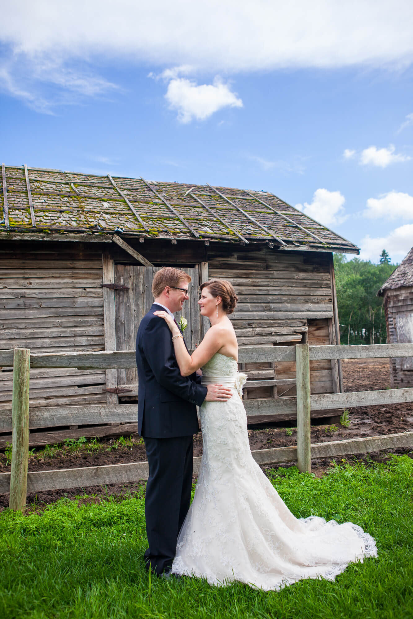 Bride and Groom posed in front of Rustic Building