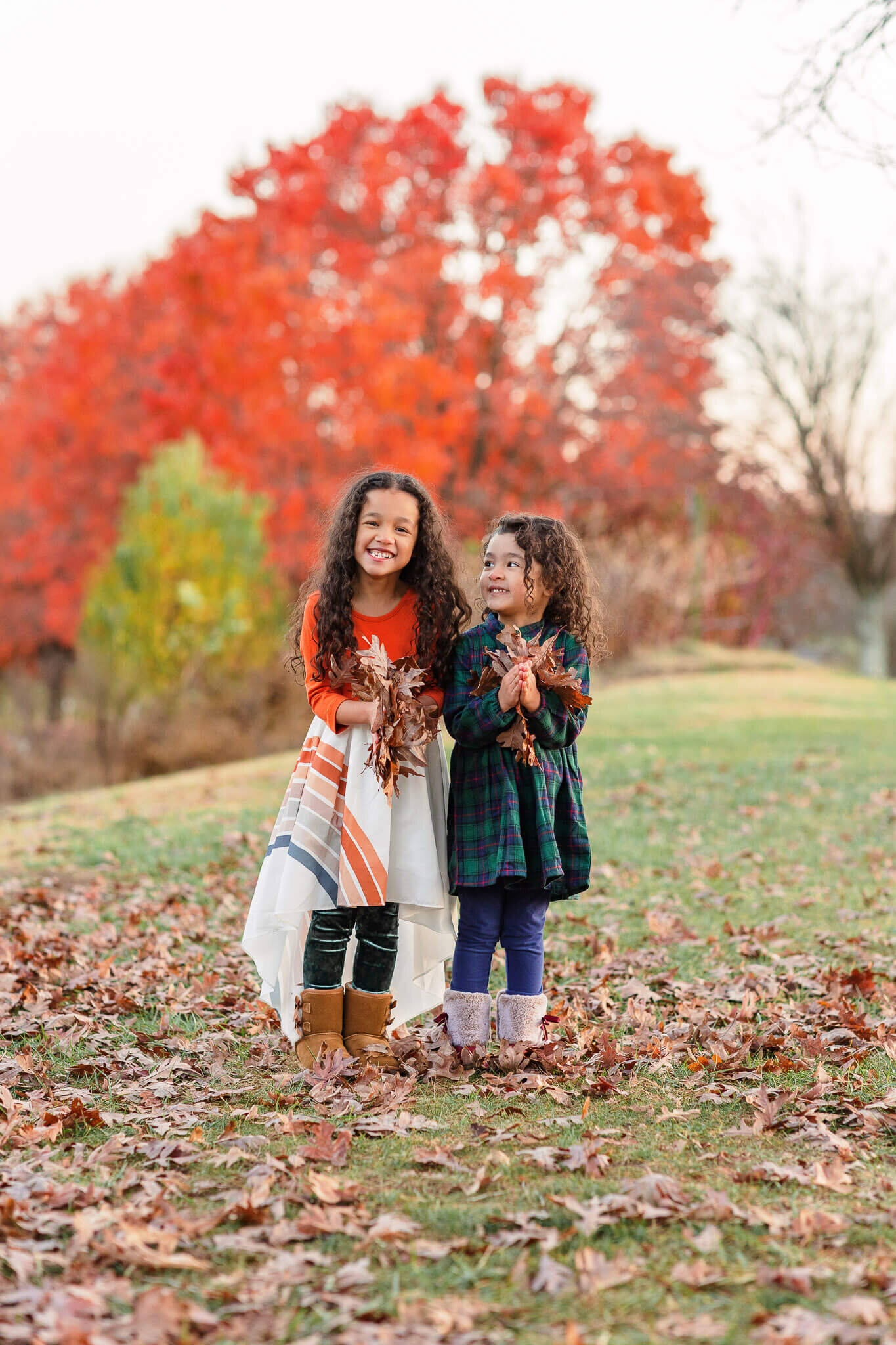 Sisters preparing to throw leaves in the air