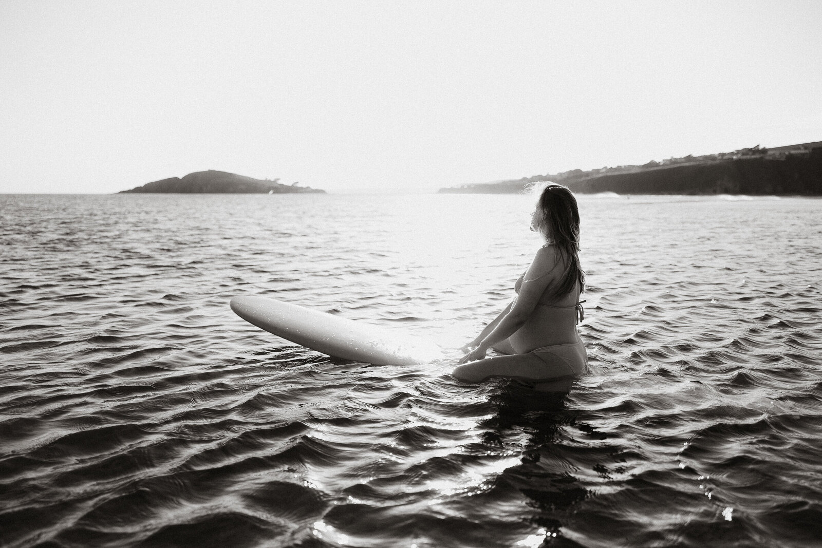 Portrait of pregnant woman on a surfboard in the sea