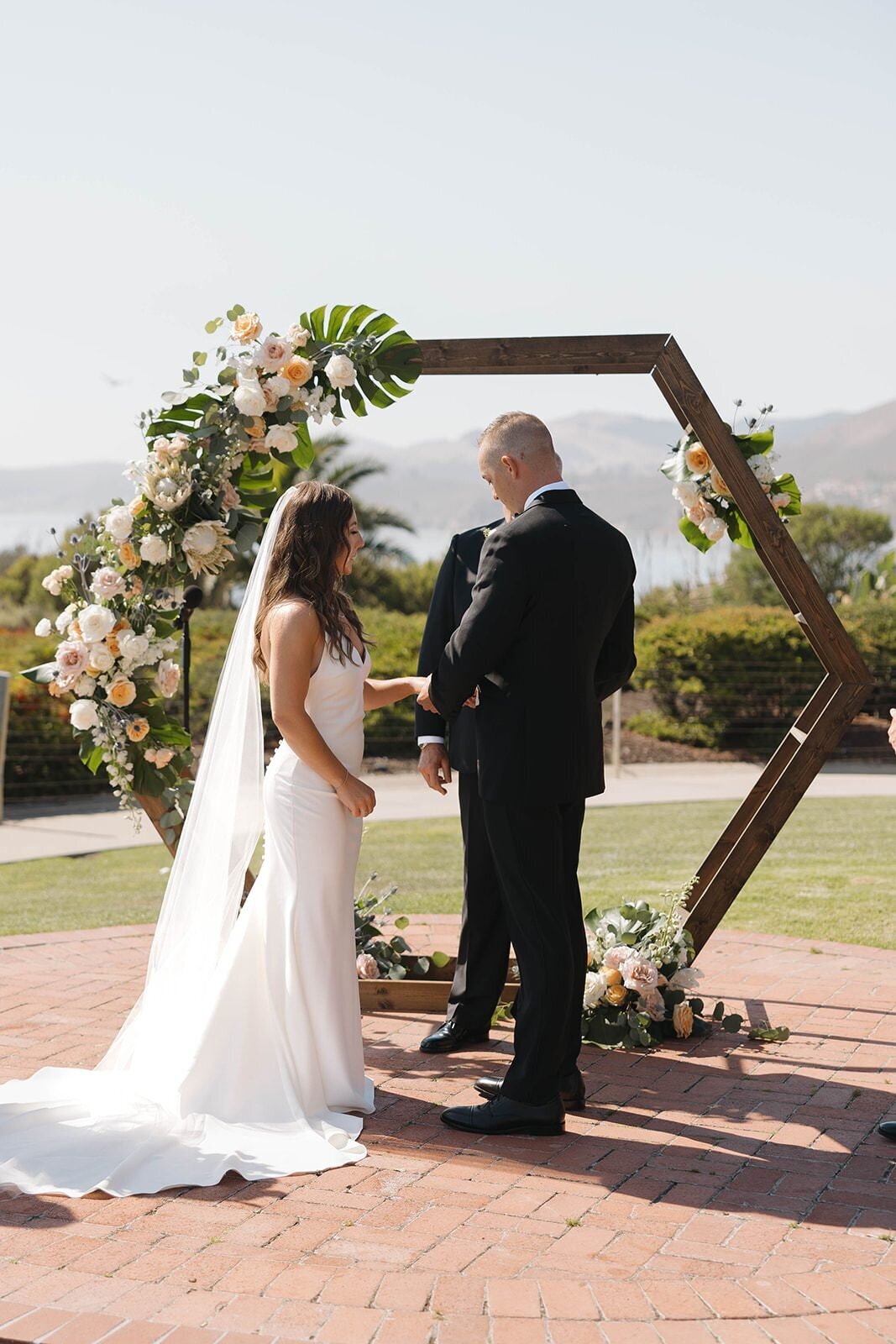 Bride and groom saying their vows under a hexagon arbor