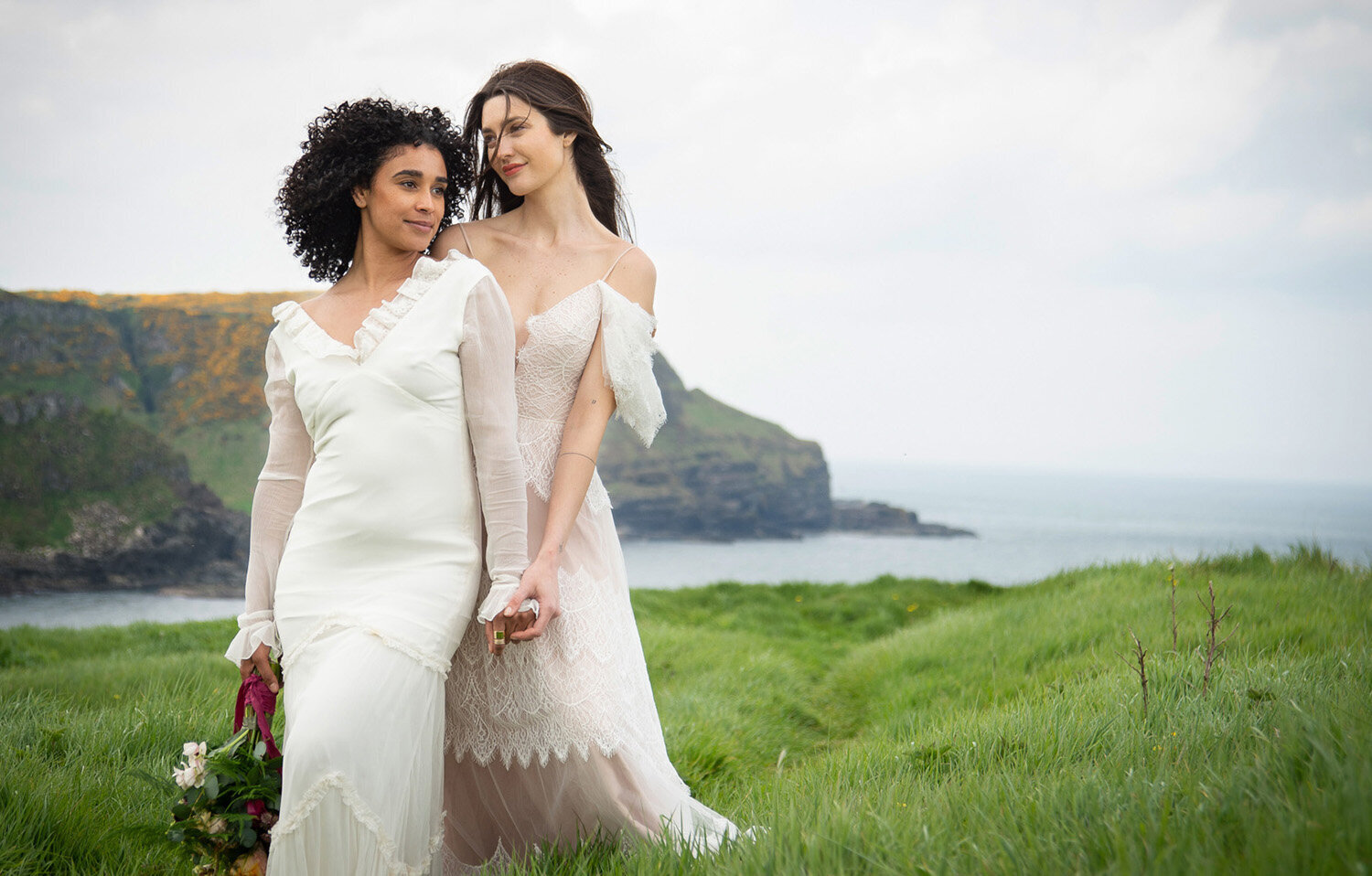 two brides on a high bluff looking into the distance