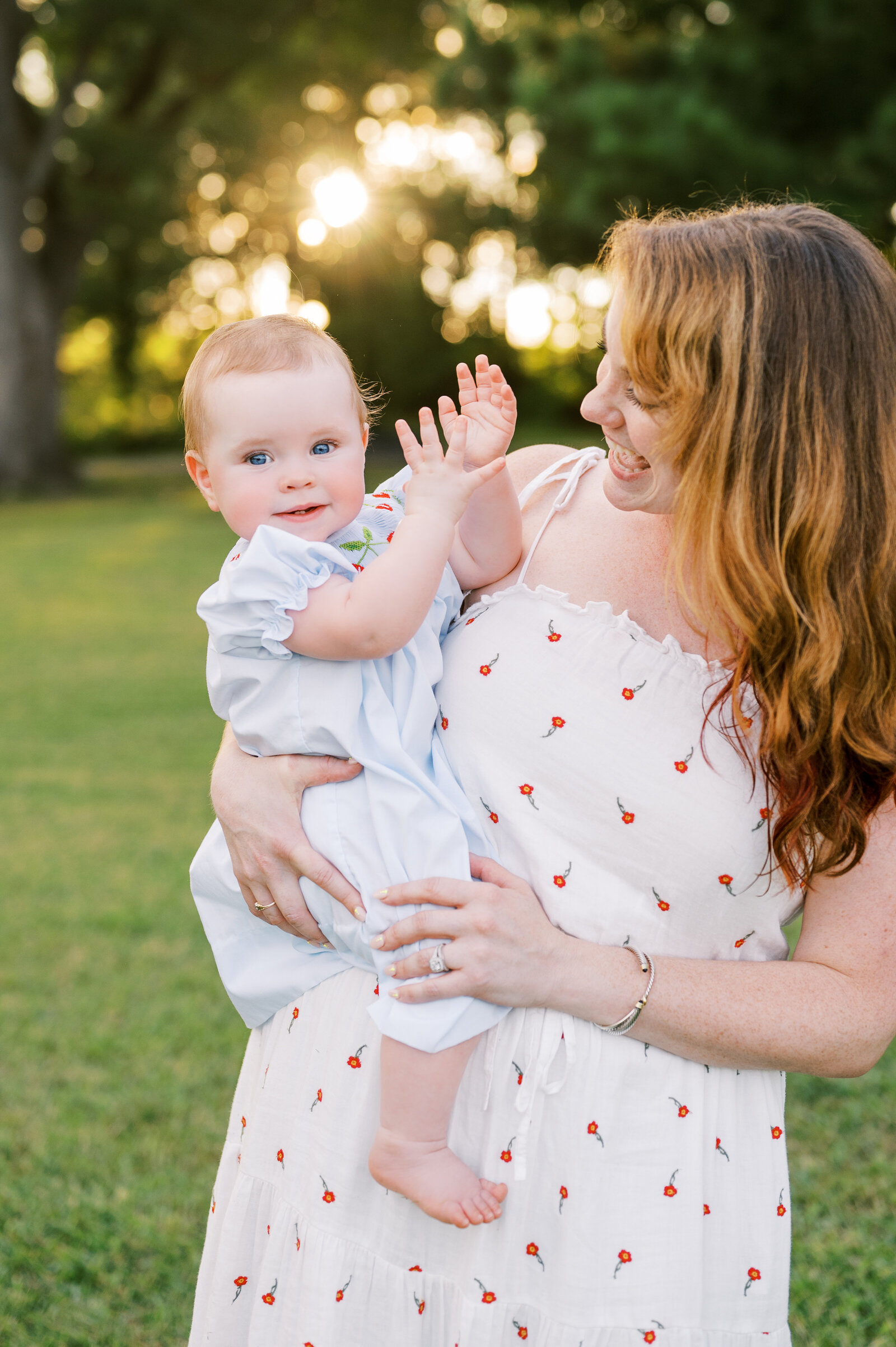 Mom holds baby girl during sunset family photo session in Raleigh, NC