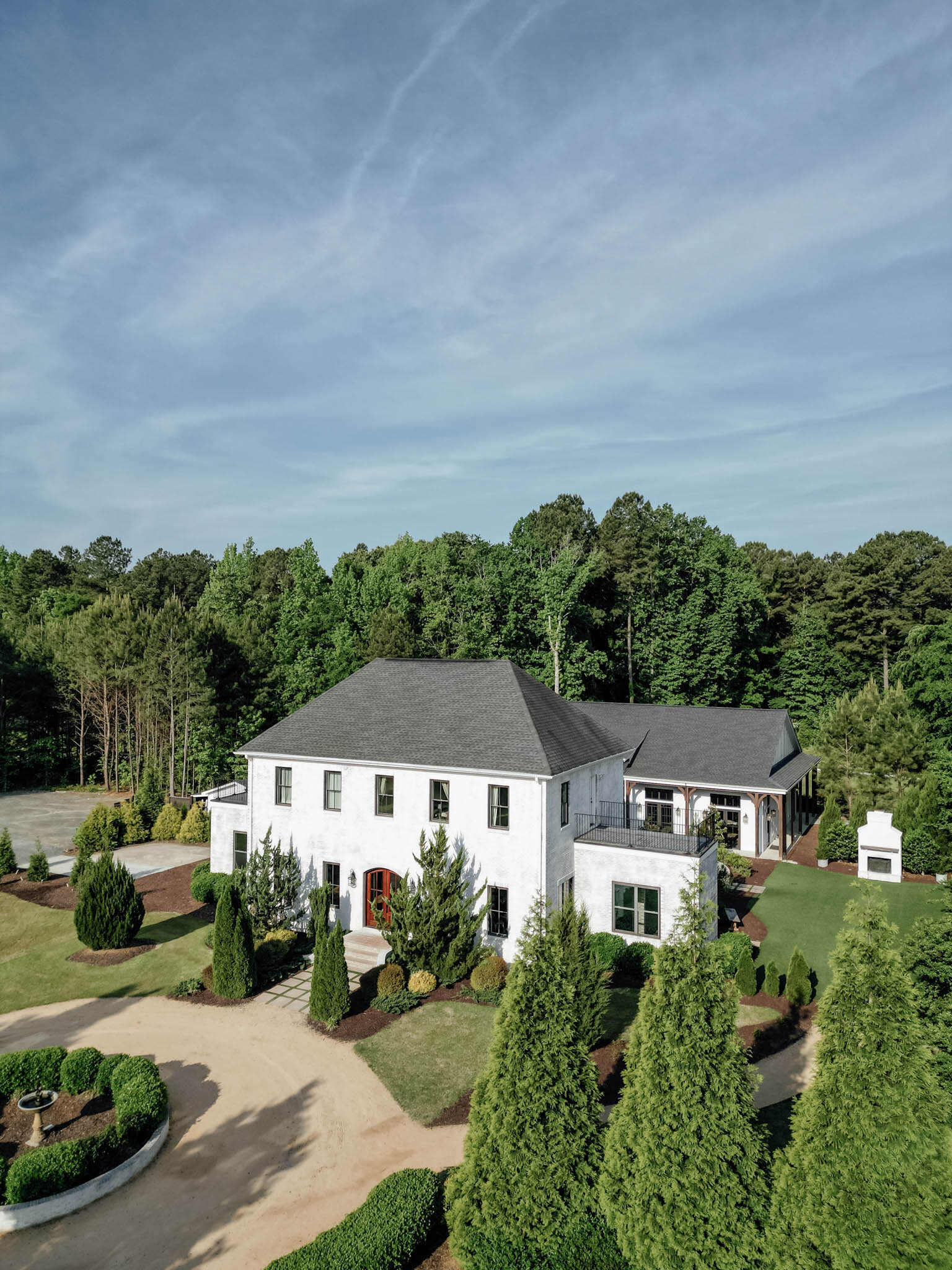 Aerial view of white wedding venue surrounded by trees