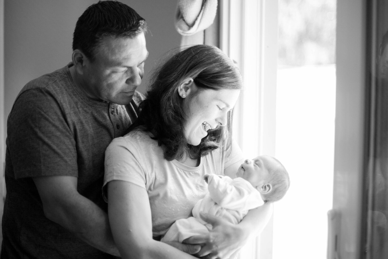 A newborn being held by his family.