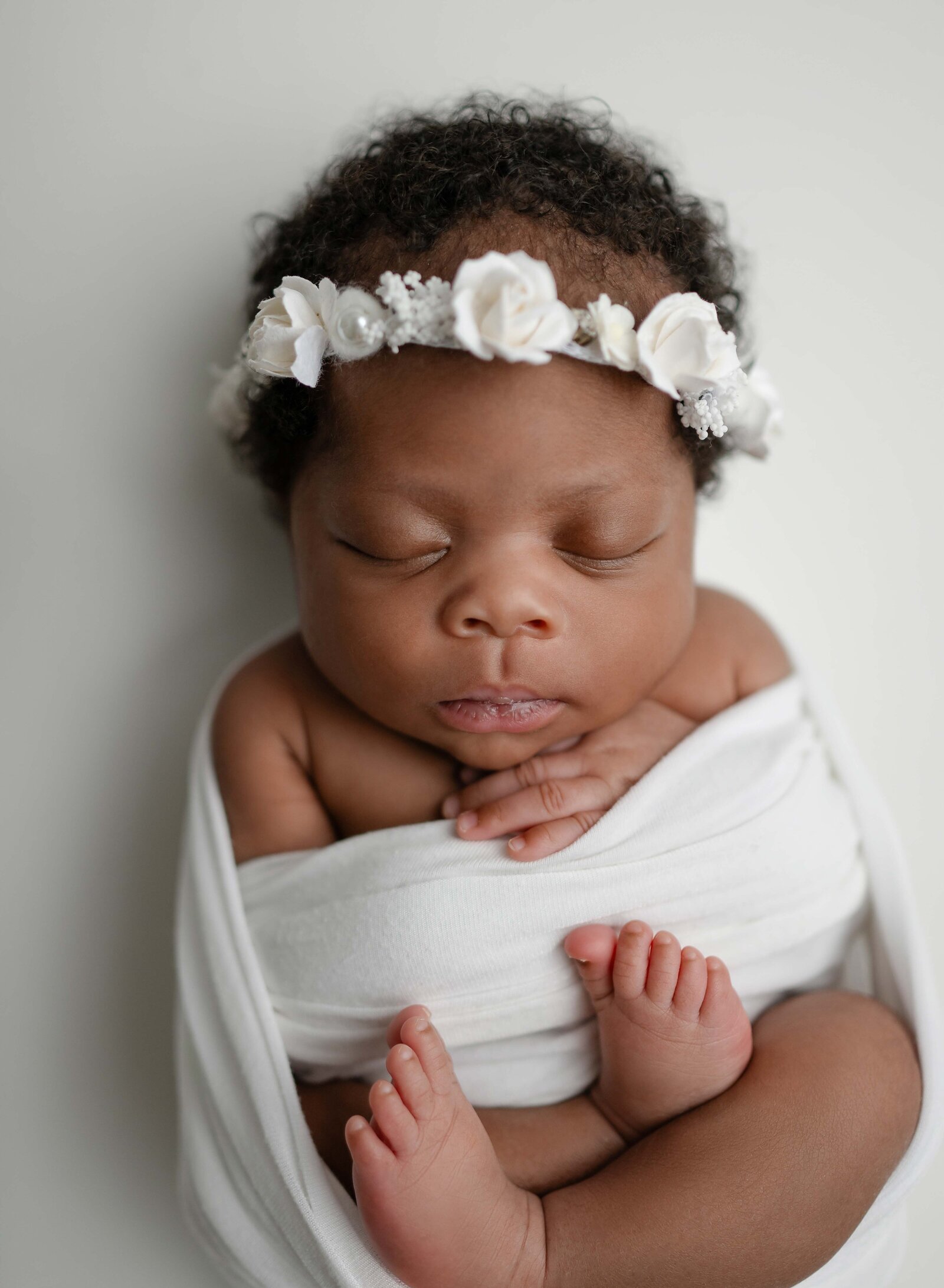 baby girl in white swaddle sleeping for newborn photoshoot in Atlanta.