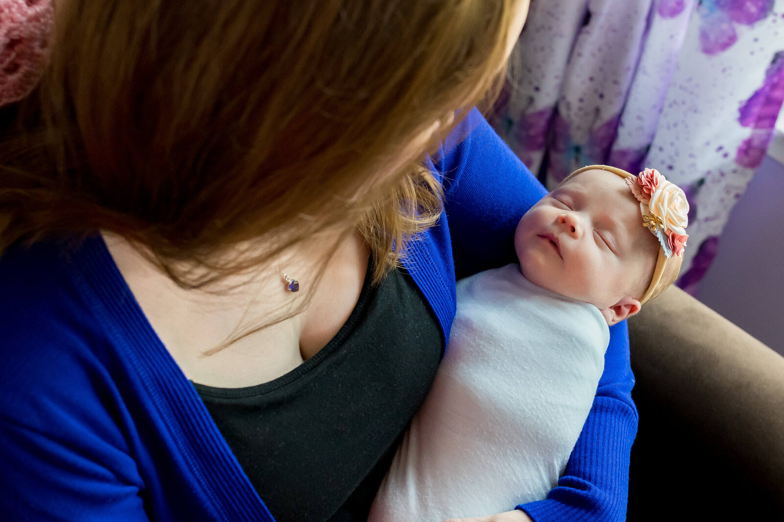 A mom snuggling her newborn girl in Manassas.