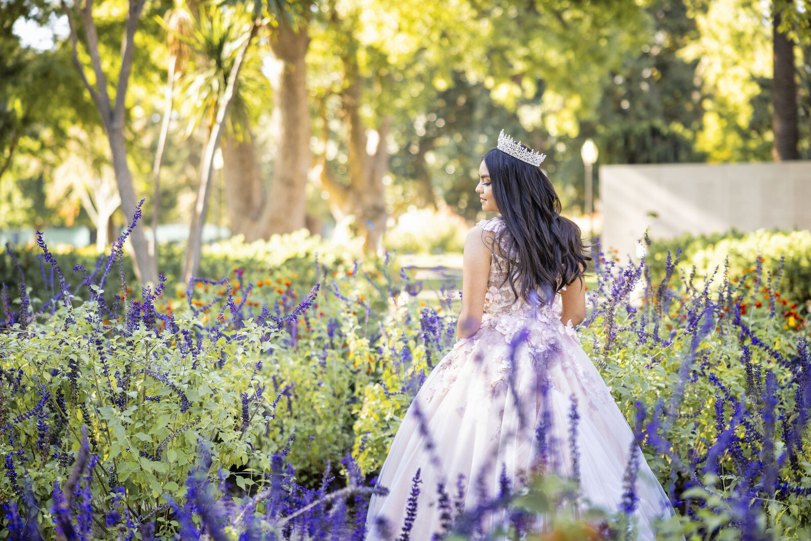 Young girl walks among flowers in bridal dress and crown.  Photo by sacramento wedding photographer philippe studio pro.