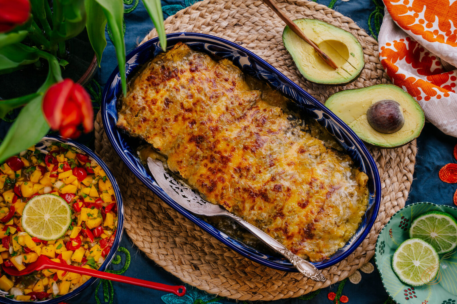 A vibrant dish of Mexican cuisine showcasing corn, creamy avocado slices, and gooey cheese, served on a rustic plate.