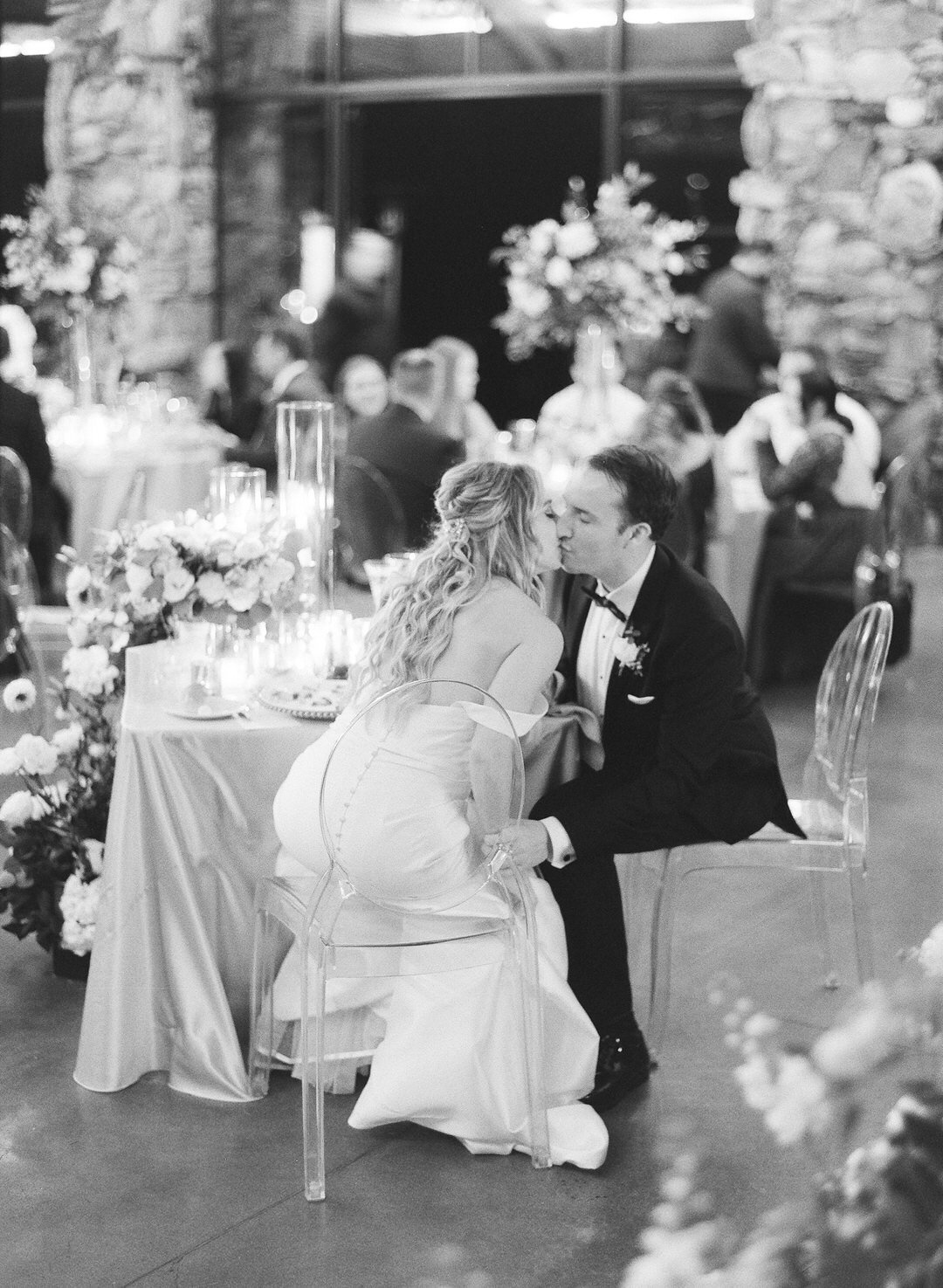 black and White of bride and groom kissing at wedding reception at Omni Grove Park Inn in Asheville