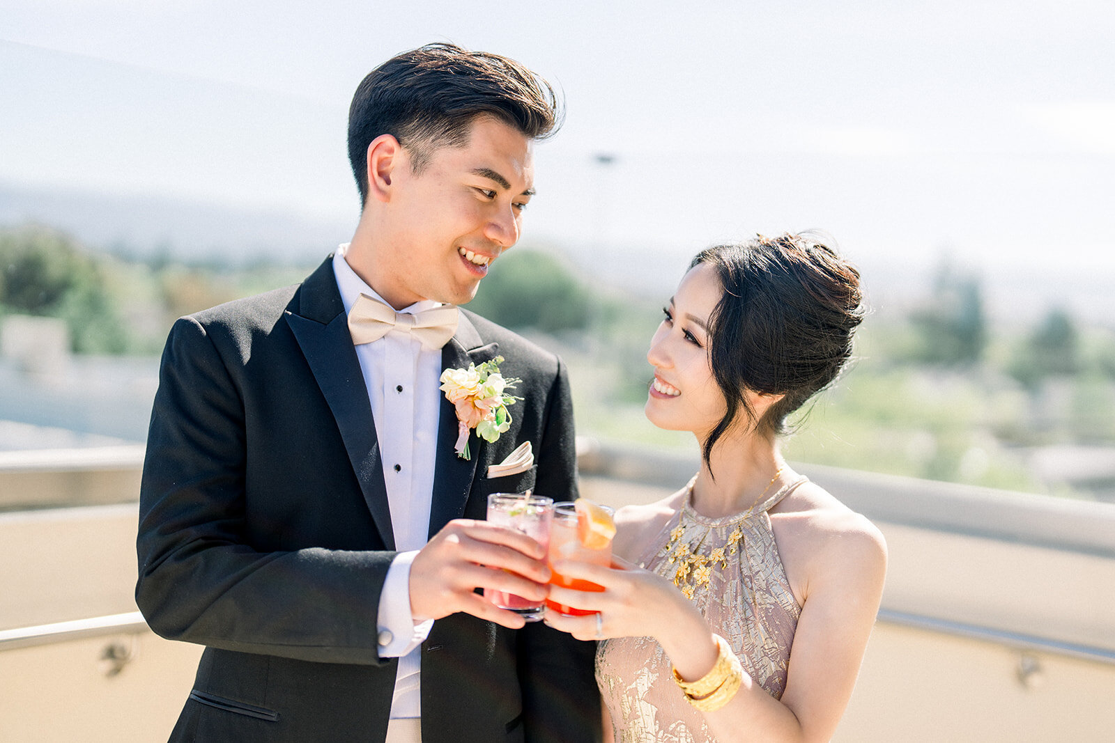 The bride and groom share a joyful toast, celebrating their love at the picturesque Stanford University wedding venue.