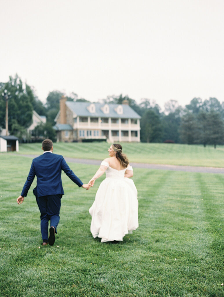 bride and groom laughing running together taken by baltimore wedding photographer Nicole Simensky