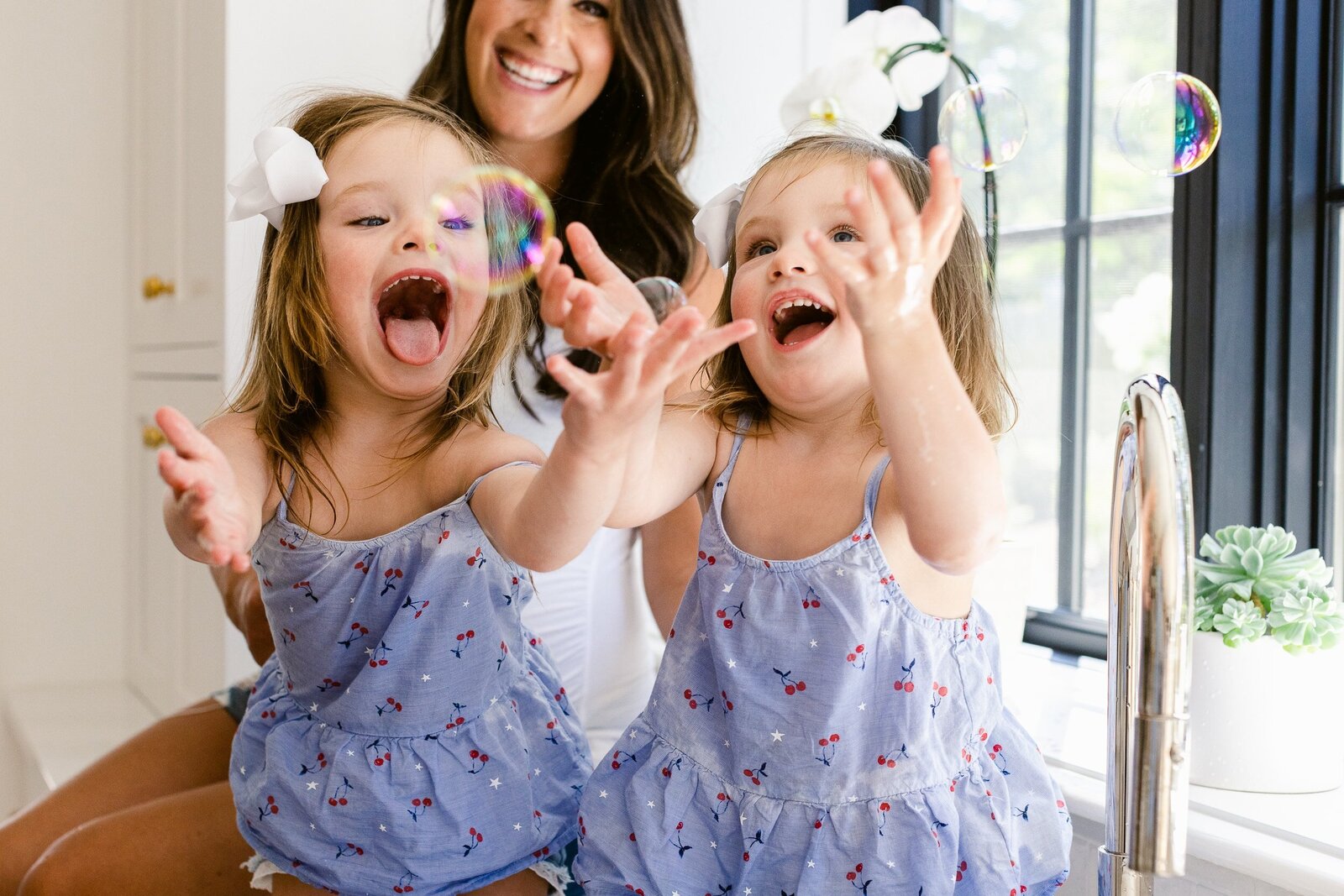 twins with bubbles in kitchen