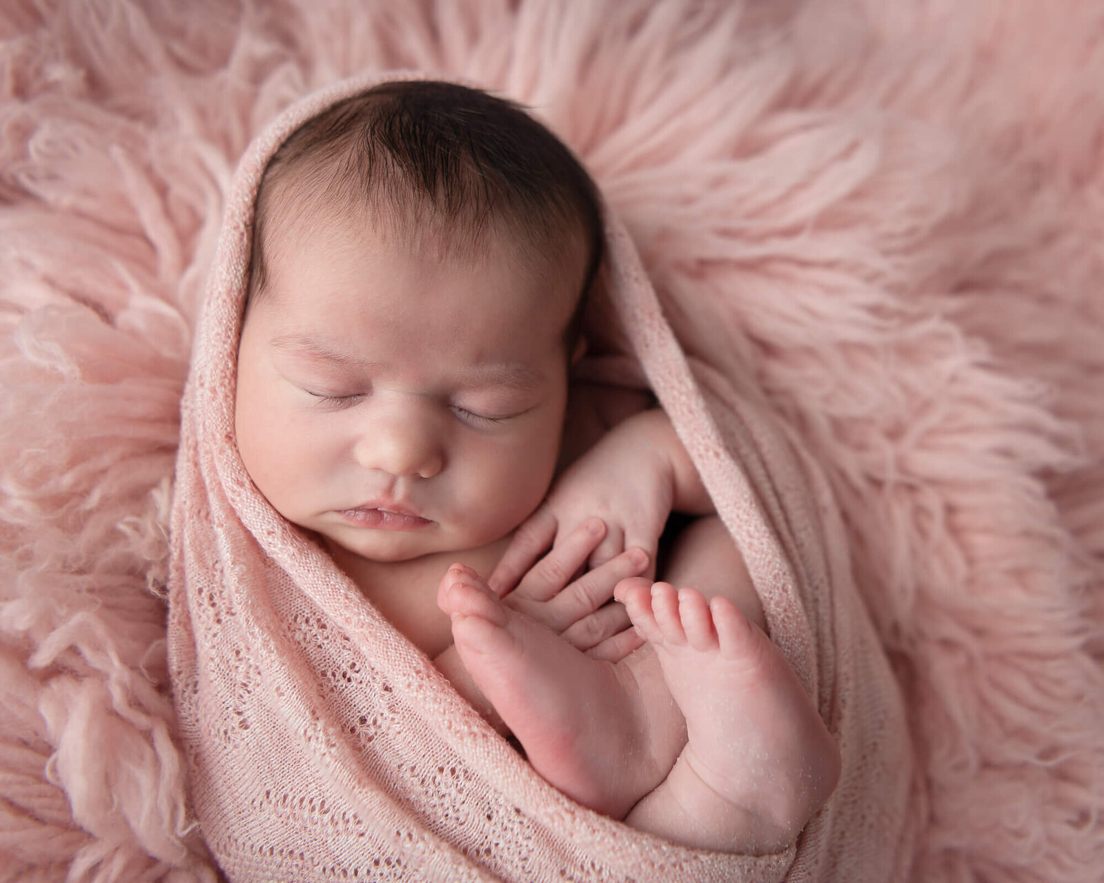 newborn wrapped up in pink