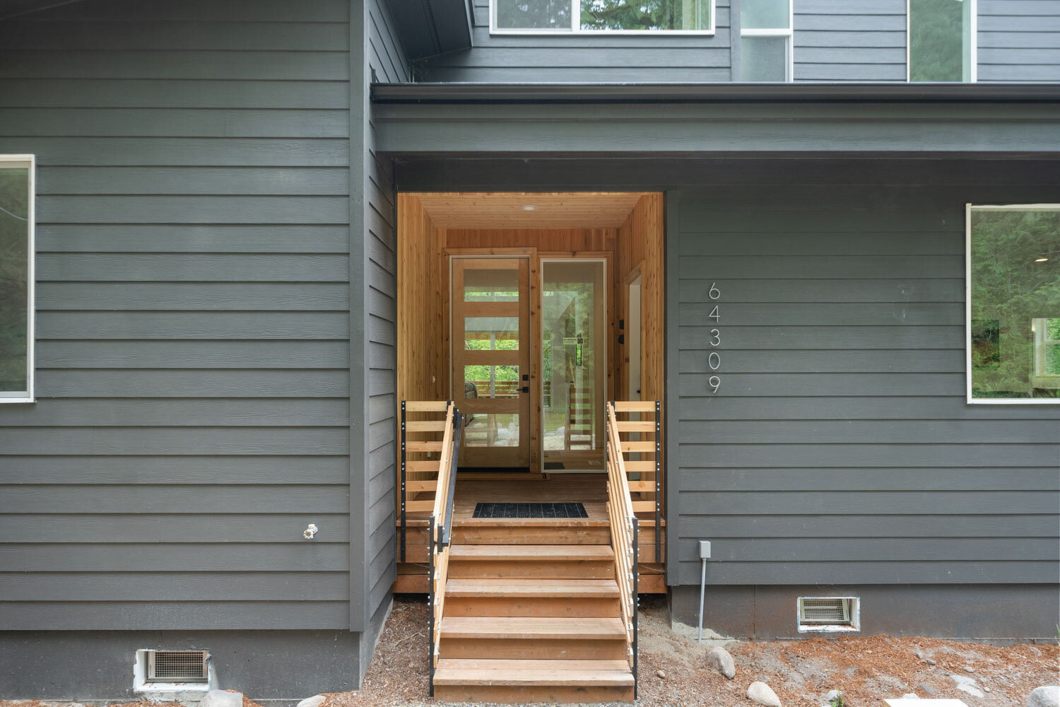 Wooden front entryway with stairs leading to a glass door