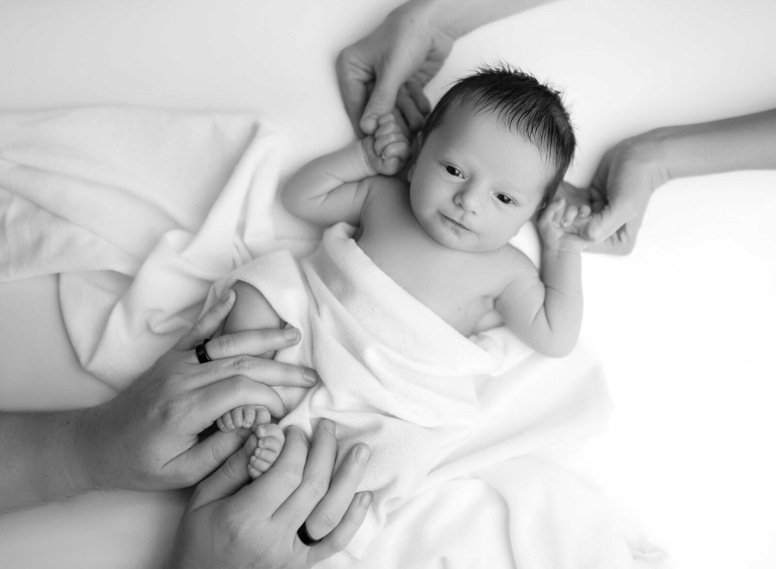 Dad holding baby's toes and Mom holding baby's hands. Photographed in Atlanta, GA.