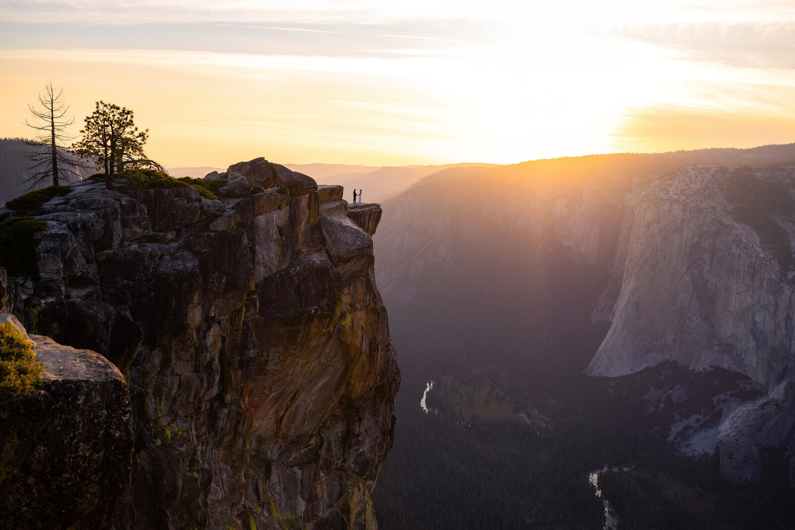 bride and groom on a ledge at taft point yosemite