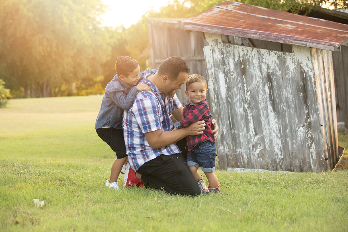 Boys playing with dad during McKinney family photos.