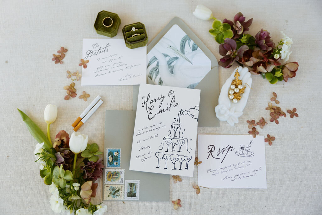 uxury wedding invitation flat lay with jewelry, stamps, and floral accents for a garden party wedding in Los Angeles, styled by Jasper & Lane Events