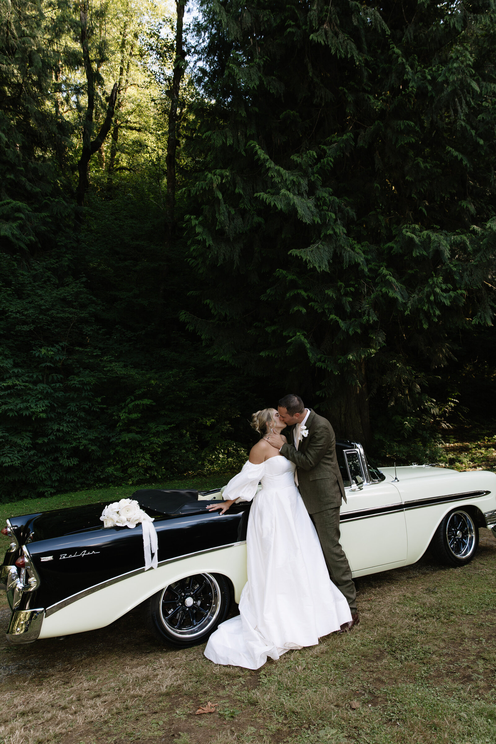 Bride leaning on vintage classic car for bridal portraits in Washington