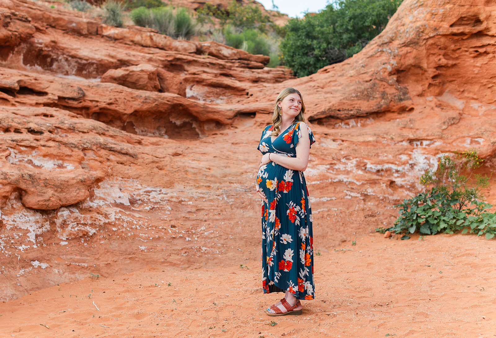 mom holds her belly as she poses for maternity photos in st. george, utah