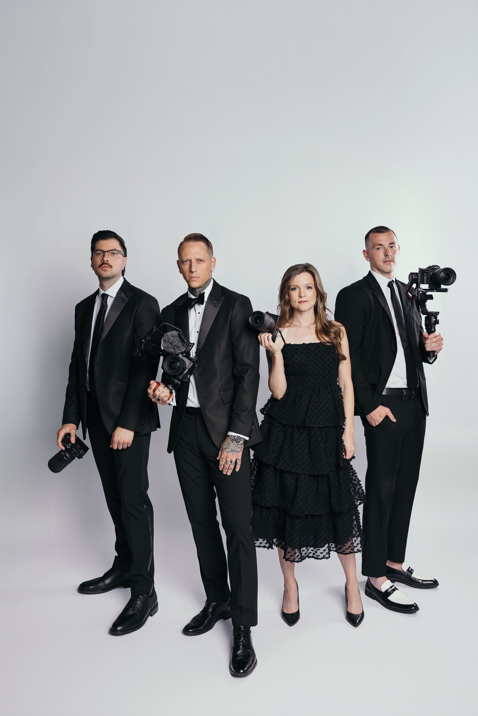 The Proper Collective creative team holding cameras — expert wedding videographers and photographers in the Midwest.