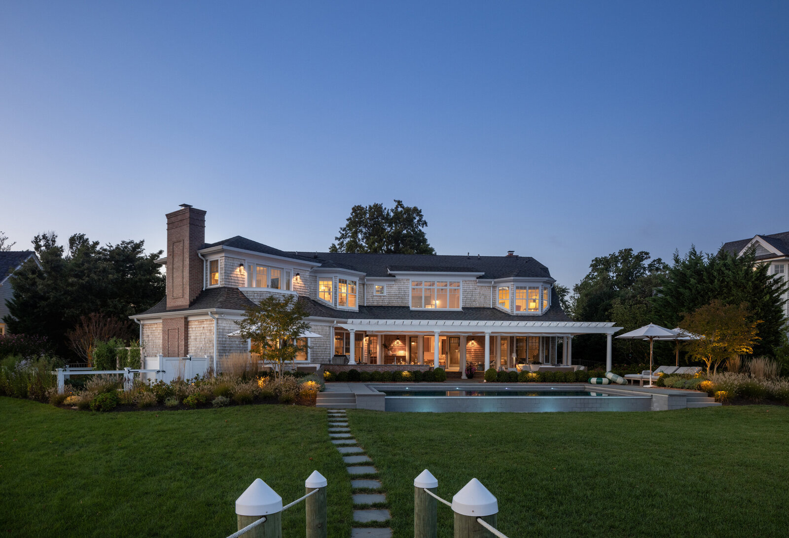HAMPTONS STYLE COASTAL POOL AND YARD AT DUSK