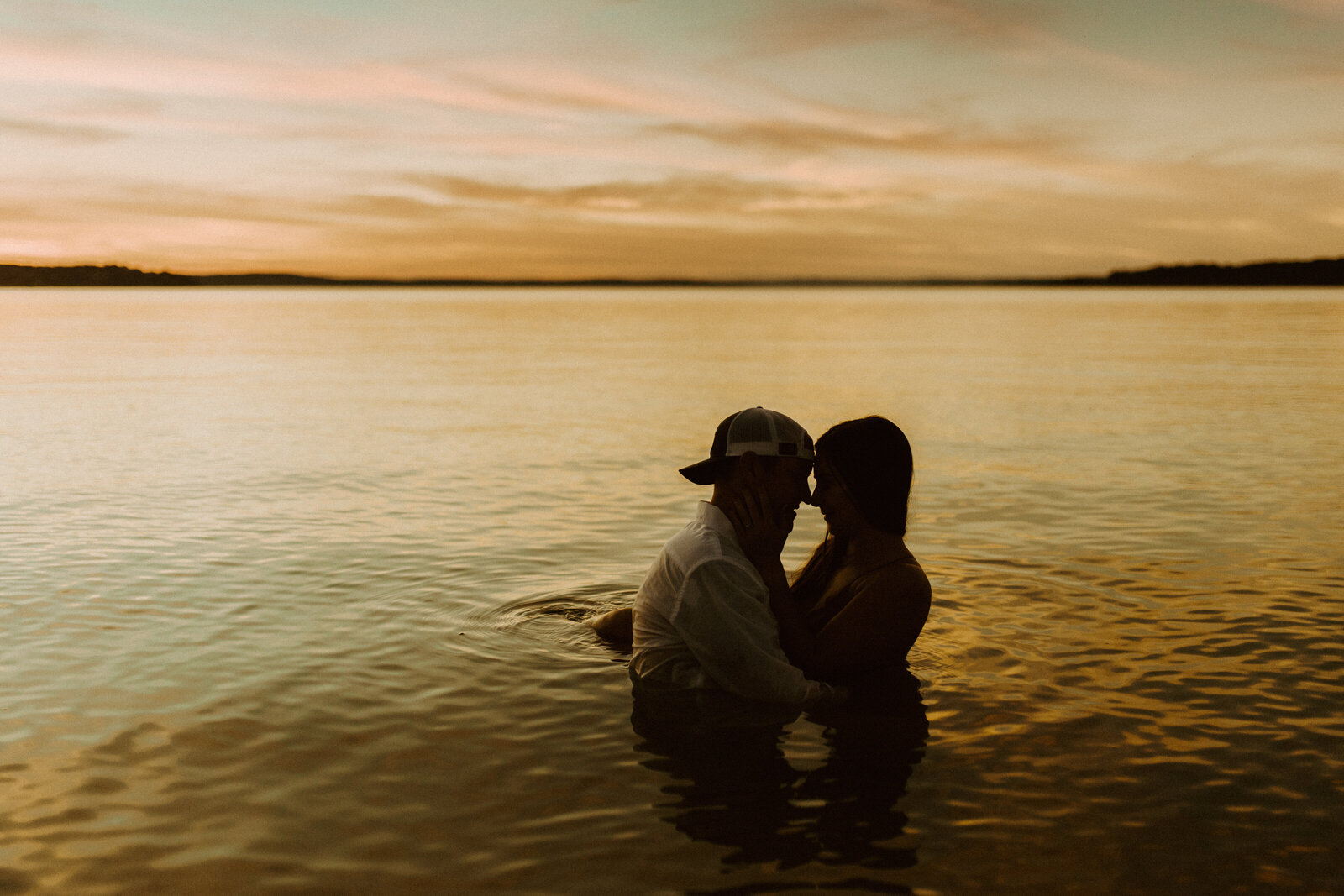 couple in lake together at sunset