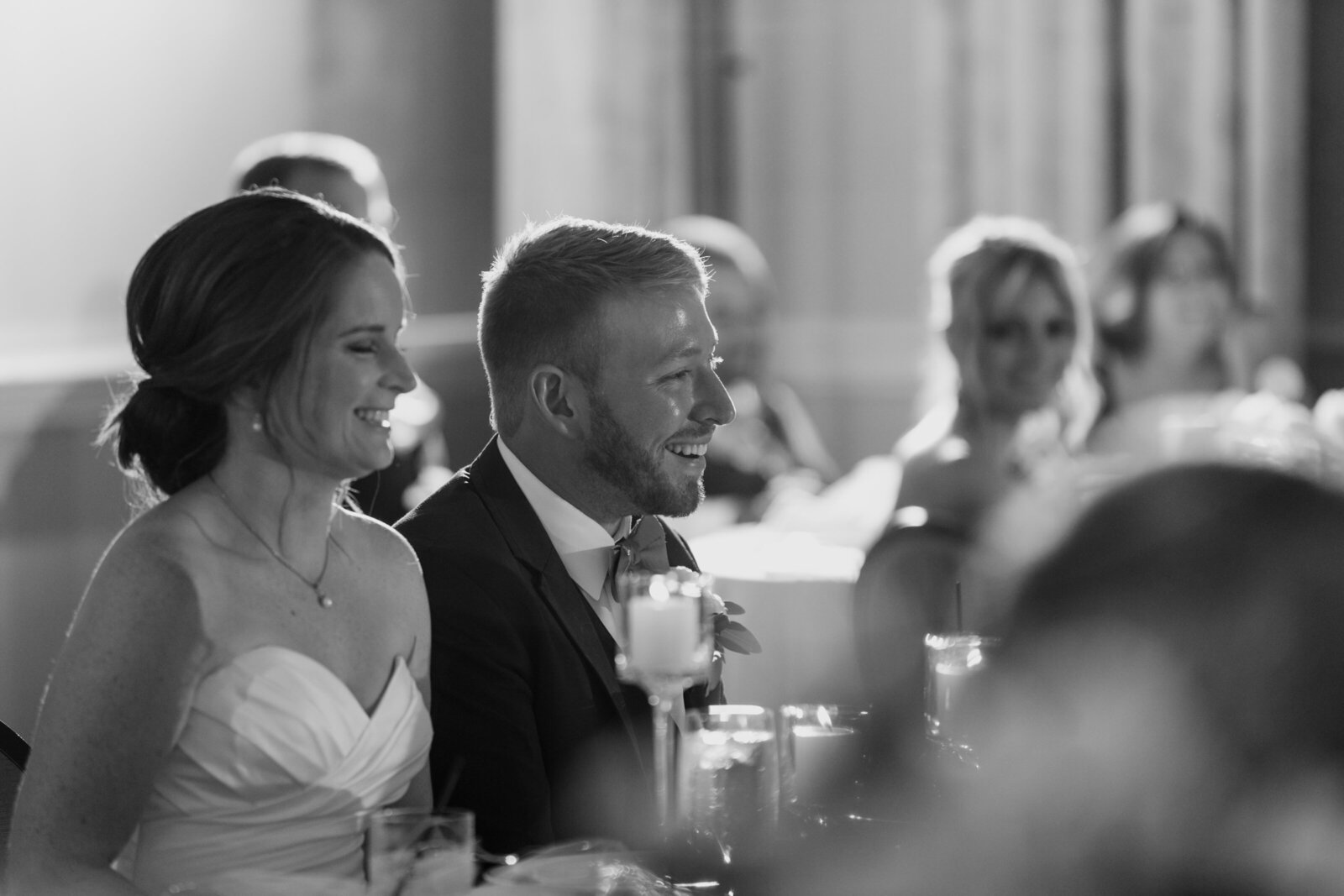 A bride and groom laugh during their wedding reception