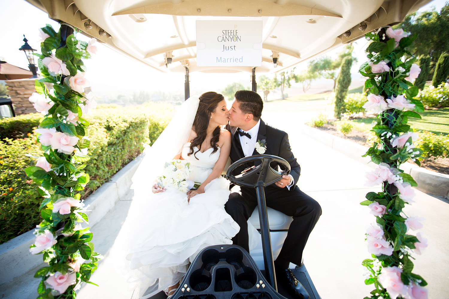 bride and groom kissing in golf cart