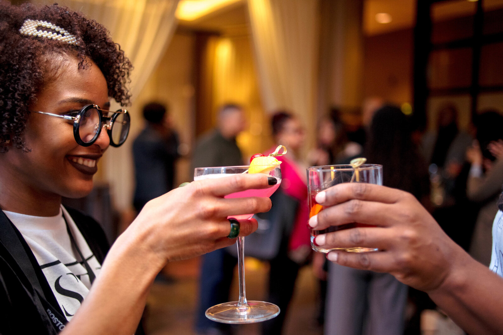 Two woman toast at cocktail hour.