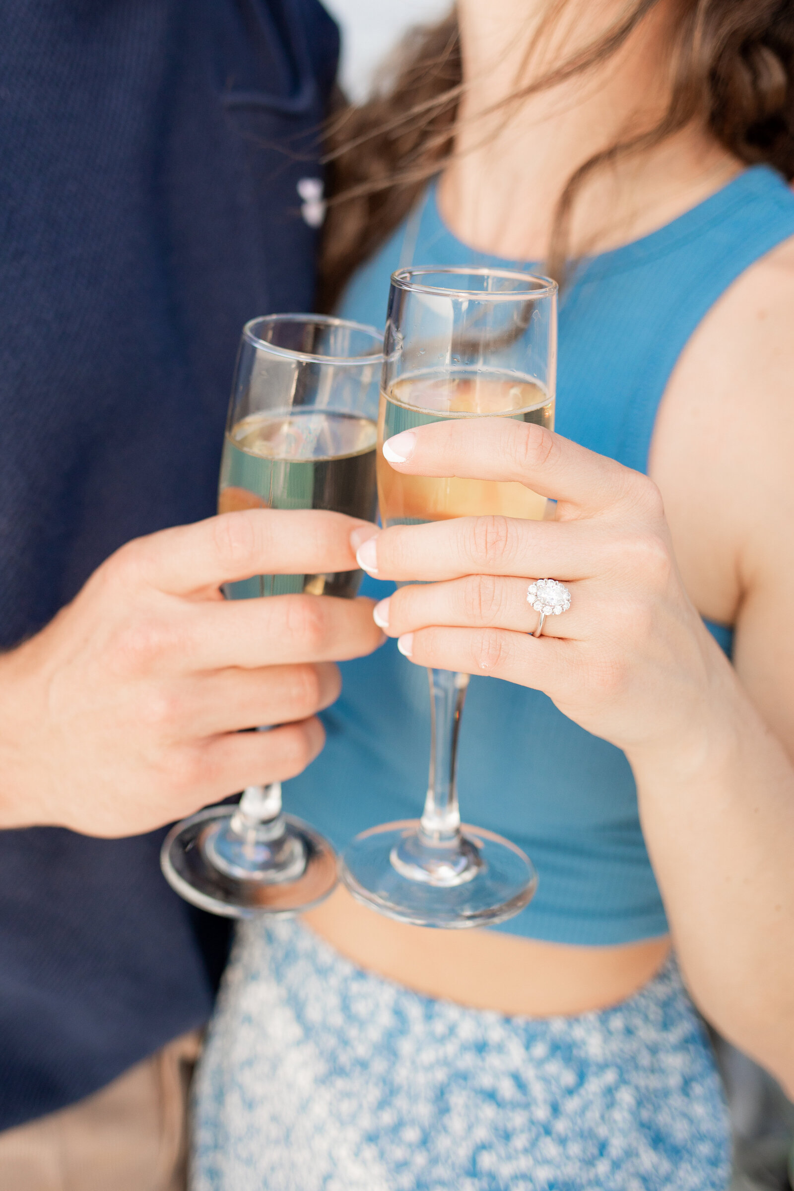 blue shirt girl clinking champagne with fiance in sea bright