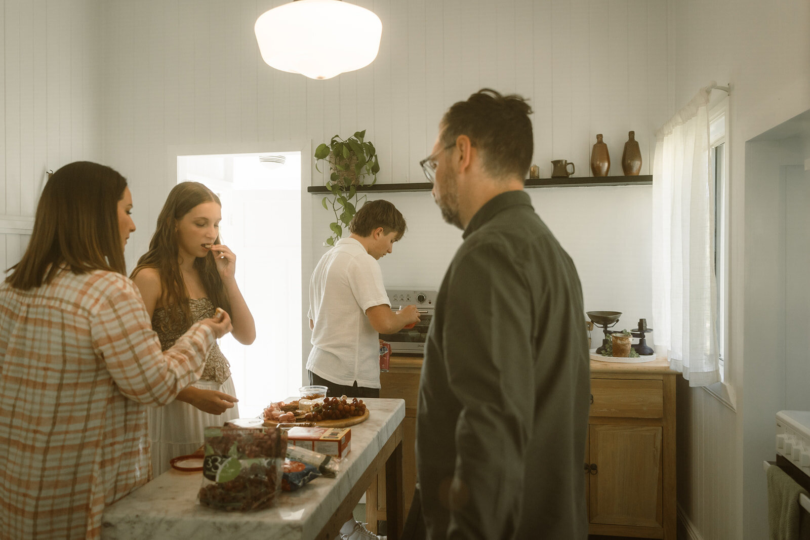 queenslander style home indoors, newly renovated with the family eating inside in the kitchen for family photos