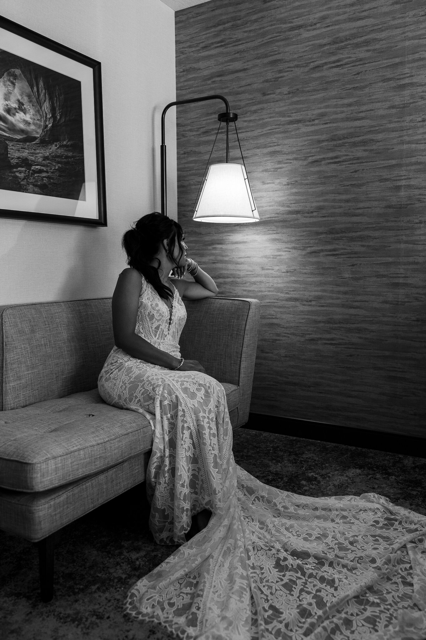 Bride sitting on couch in wedding gown before her wedding