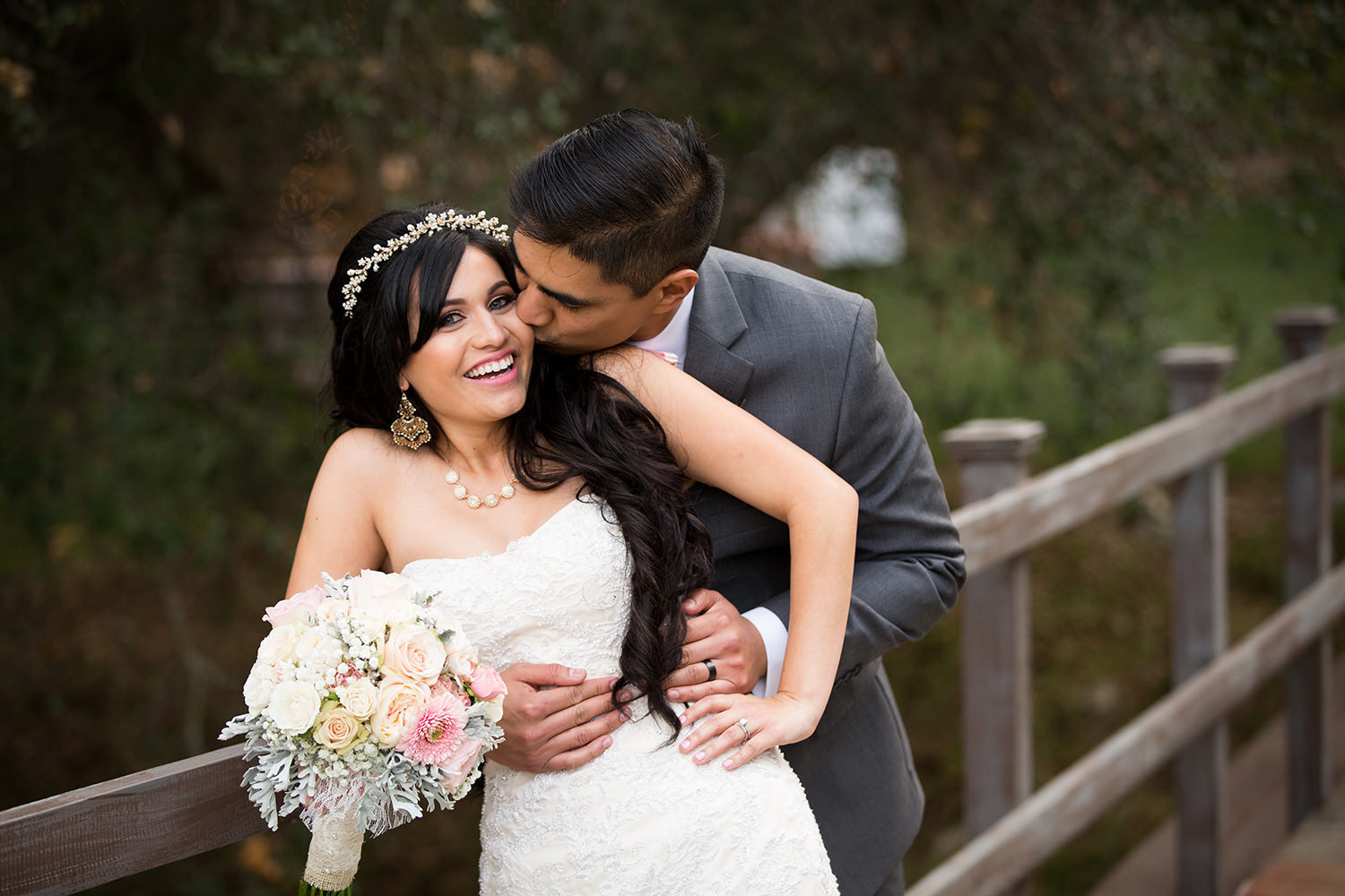 groom kissing bride on bridge at los willows