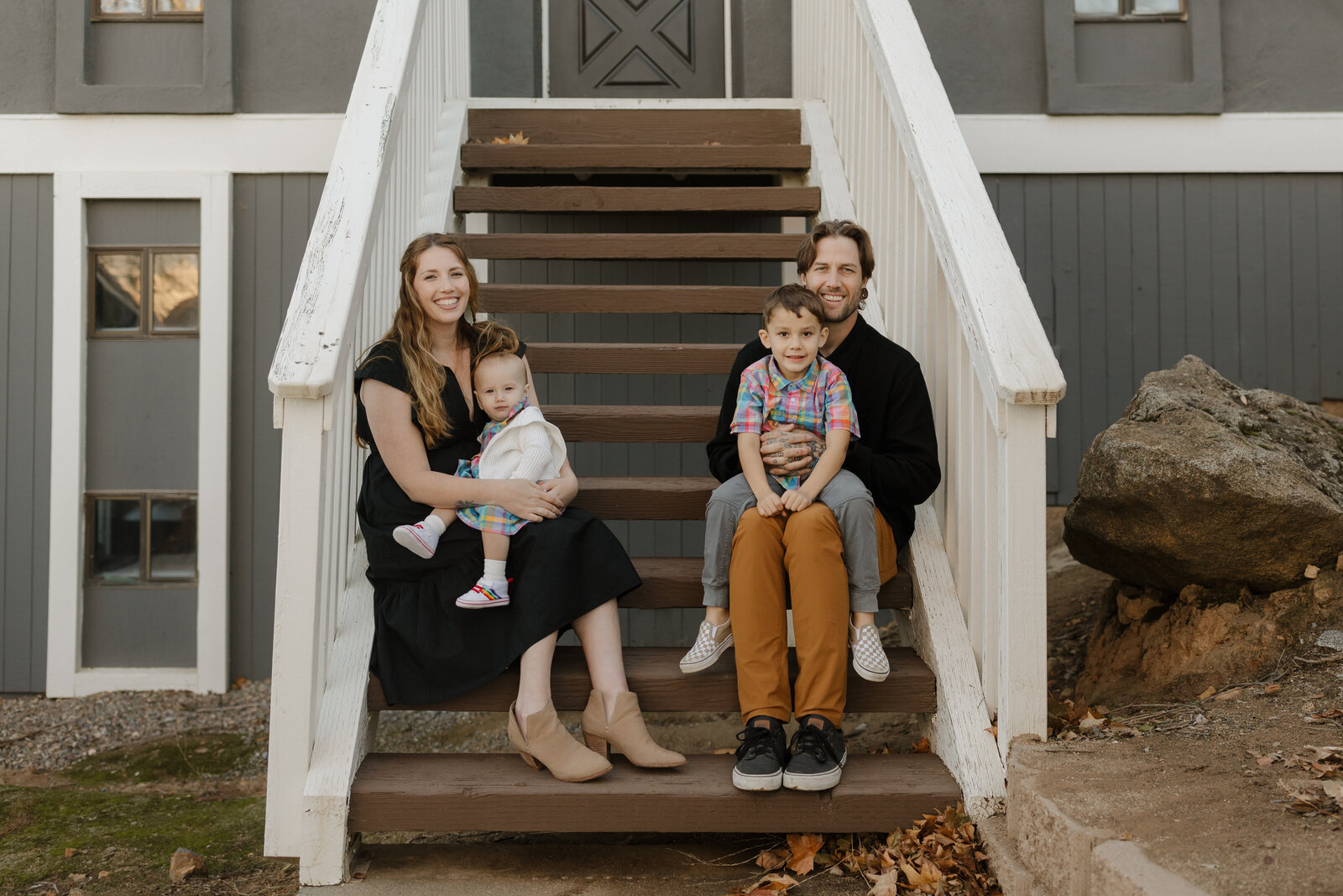 family smiling in front of a cabin