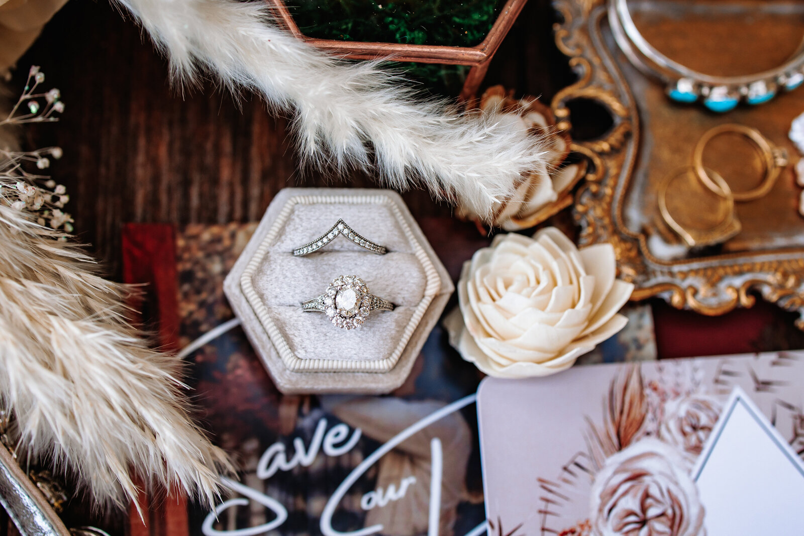 Flat lay of wedding detail items with rings front and center